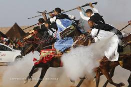 Image du Maroc Professionnelle de  Course typiquement marocaine dite ''la Fantasia'' organisé dans un site désertique sur lequel la ville de Tan Tan a toujours accueilli la majorité des tribus et des grandes familles nomades du désert lors d'un grand Moussem, Samedi 7 Septembre 2013. Le festival parrainé par l'UNESCO rassemble des milliers de nomades du Maroc. (Photo / Abdeljalil Bounhar) 